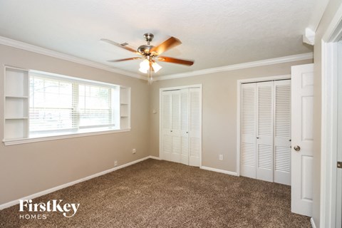 a bedroom with a ceiling fan and a closet