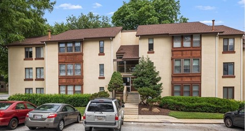 A large apartment building with a car parked in front.
