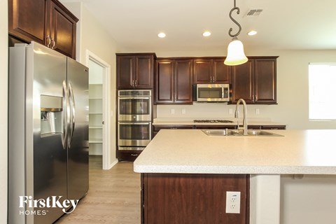 A kitchen with wooden cabinets and a stainless steel refrigerator.