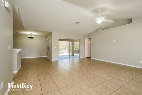A spacious room with tiled flooring and a ceiling fan.