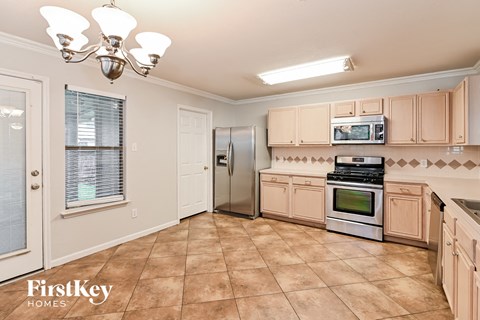 A kitchen with a tile floor and a stove top oven.