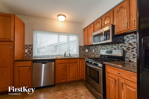 A kitchen with wooden cabinets and a black stove top oven.