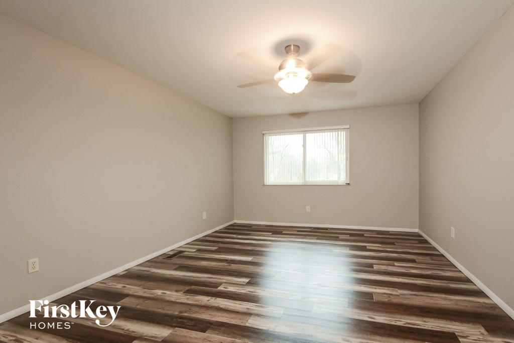 A room with a wooden floor and a ceiling fan.