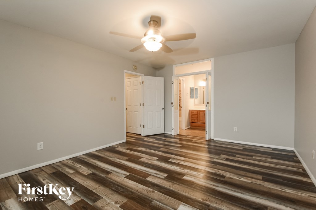 A room with wooden flooring and a ceiling fan.