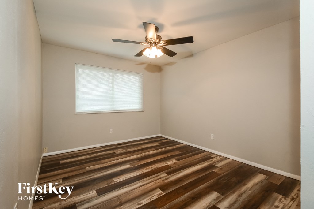 A room with wooden flooring and a ceiling fan.