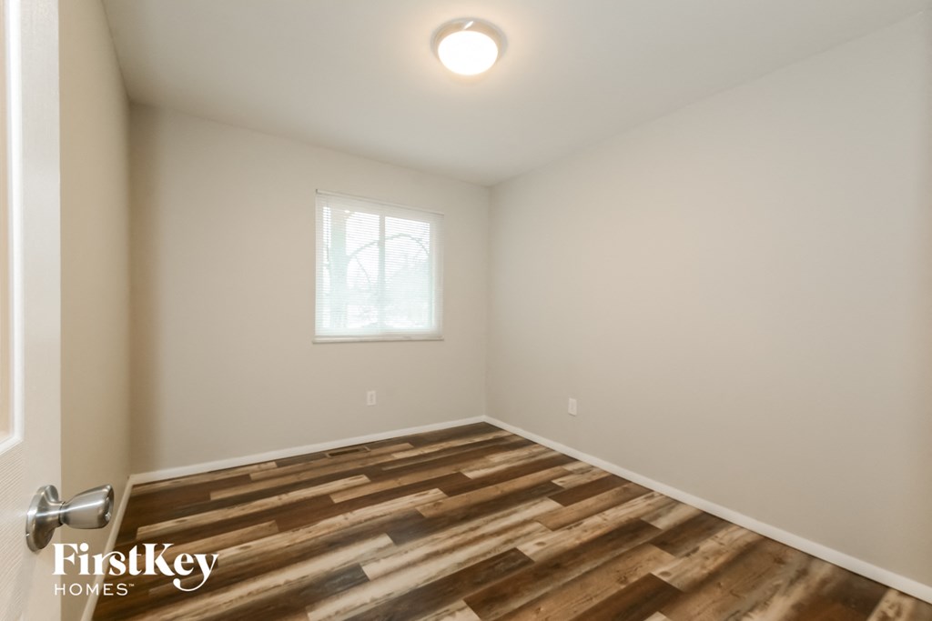 A room with wooden flooring and a window.
