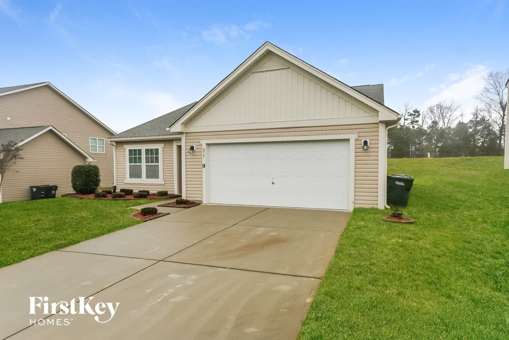 A house with a garage and a driveway in front of it.