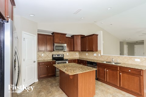 A kitchen with brown cabinets and a granite countertop.
