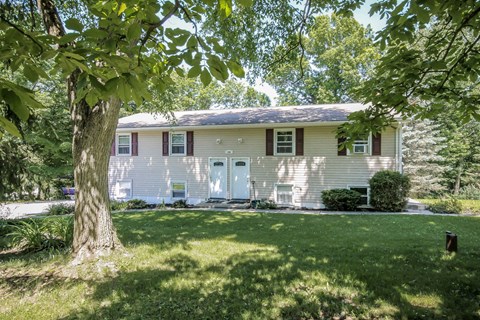 A house with a white exterior and a green lawn.