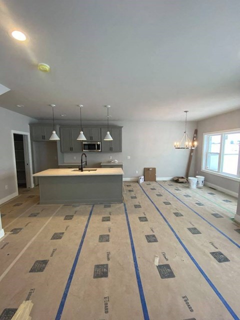 A room with a kitchen island and a dining area is under construction.