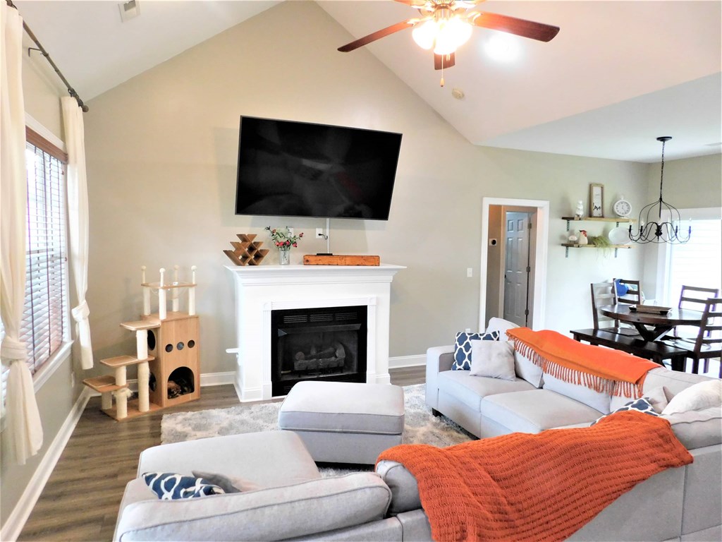 A living room with a grey couch and a fireplace.