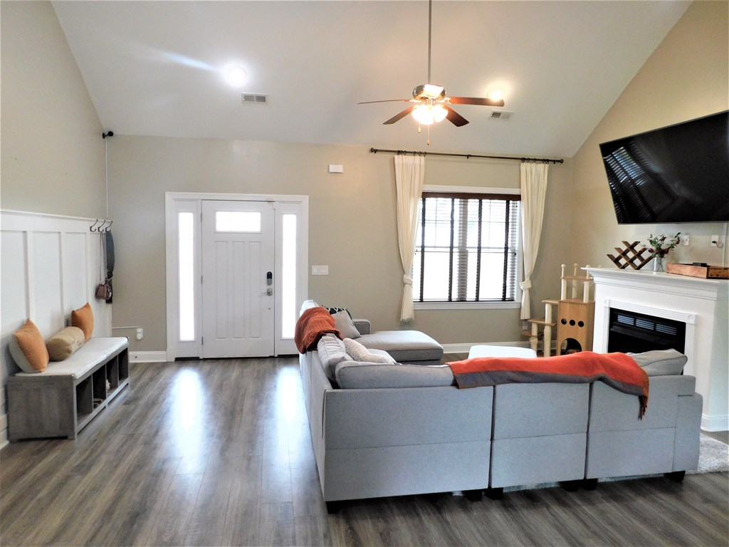 A living room with a grey couch and a fireplace.