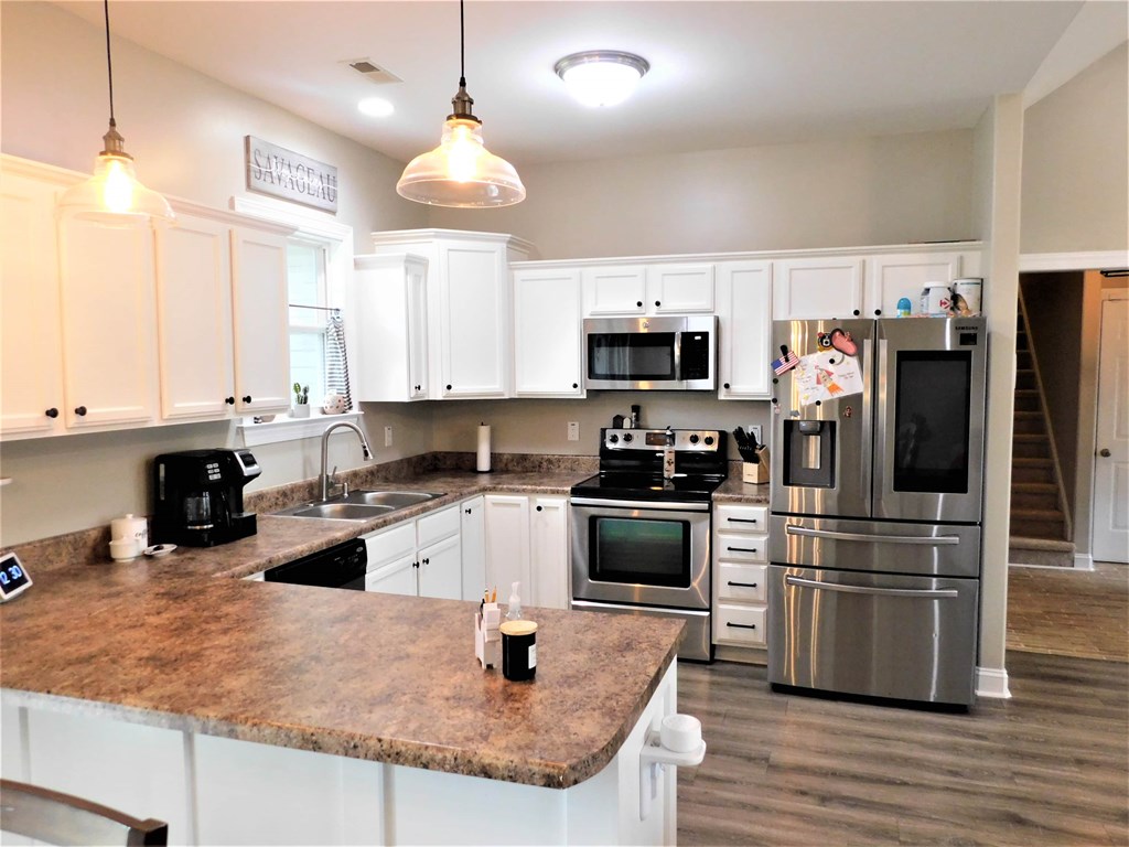A kitchen with white cabinets and a granite countertop.