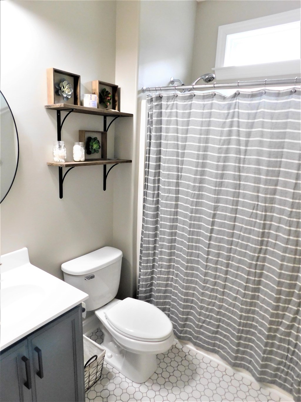A bathroom with a toilet, sink, and shower curtain.