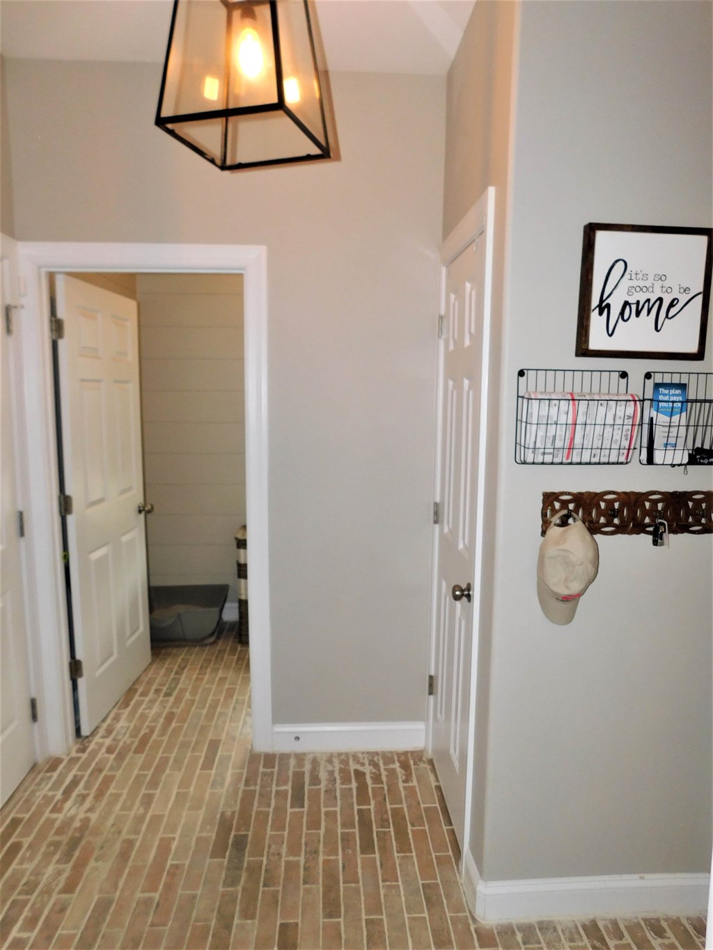 A hallway with a white door and a sign that says it's not good to be home.
