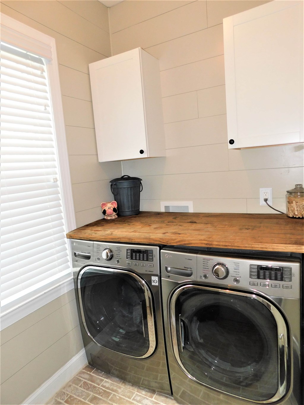 A washer and dryer are on a counter in a laundry room.