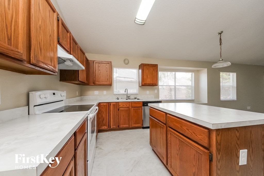 a kitchen with wooden cabinets and white counter tops