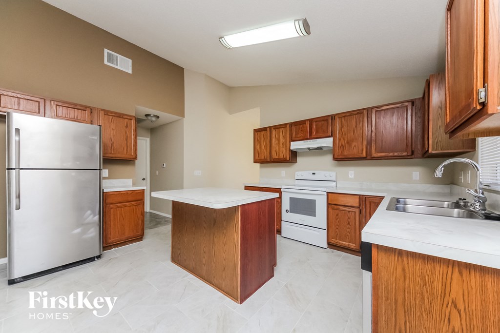 a kitchen with wooden cabinets and white appliances and a stainless steel refrigerator
