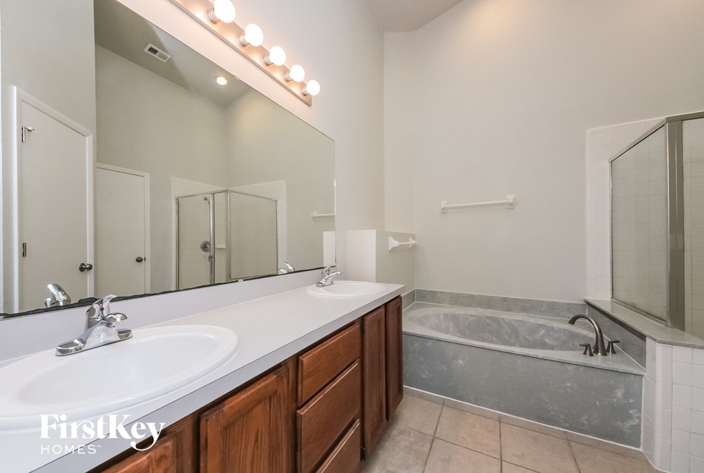 a bathroom with a sink and a tub and a mirror
