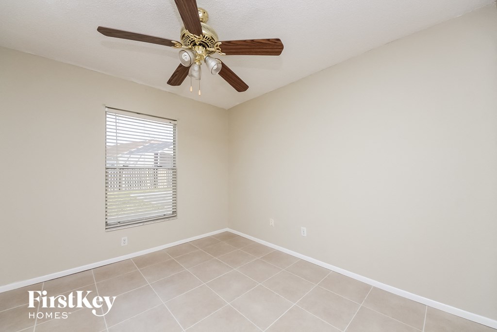 a living room with a ceiling fan and a tiled floor