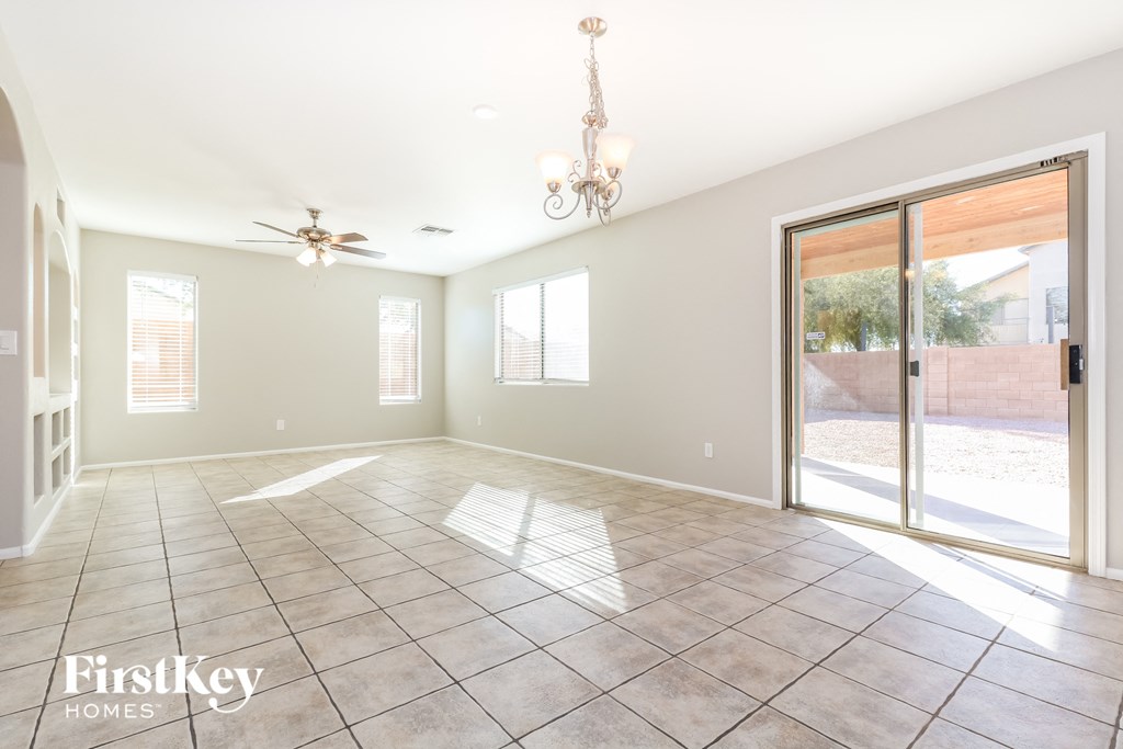 an empty living room with sliding glass doors to a patio