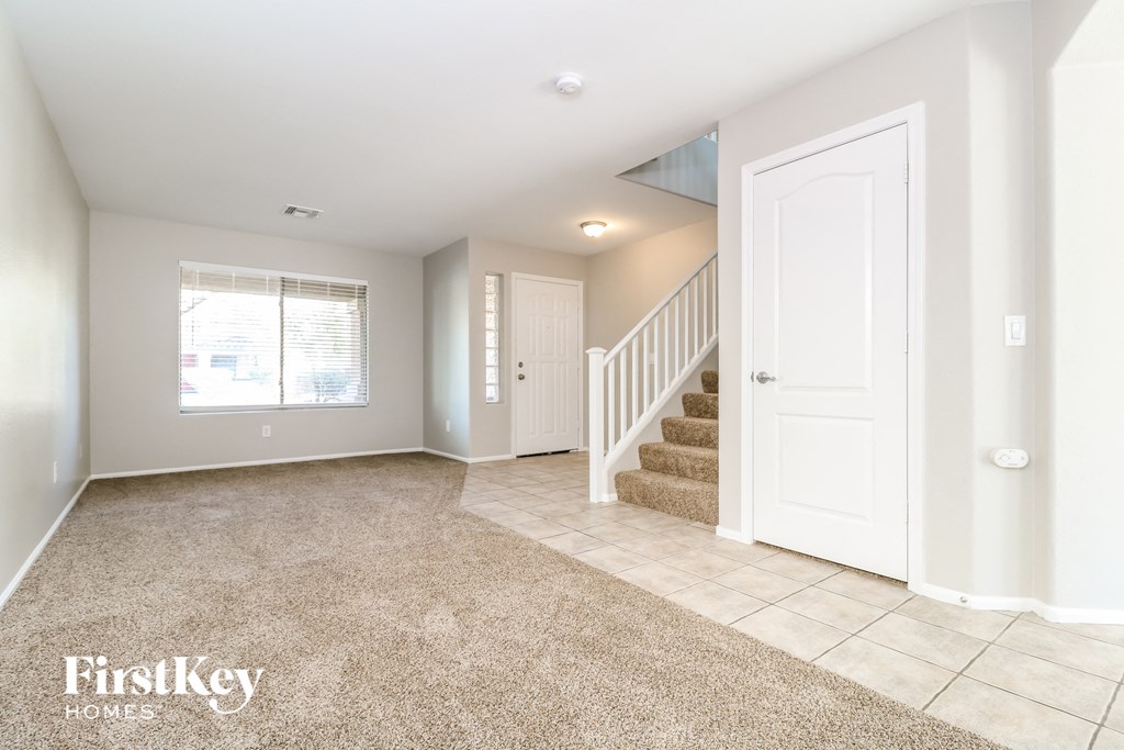 a entryway with a staircase and a white door and a tile floor