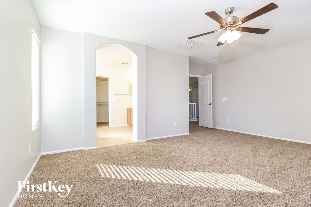 a living room with carpet and a ceiling fan