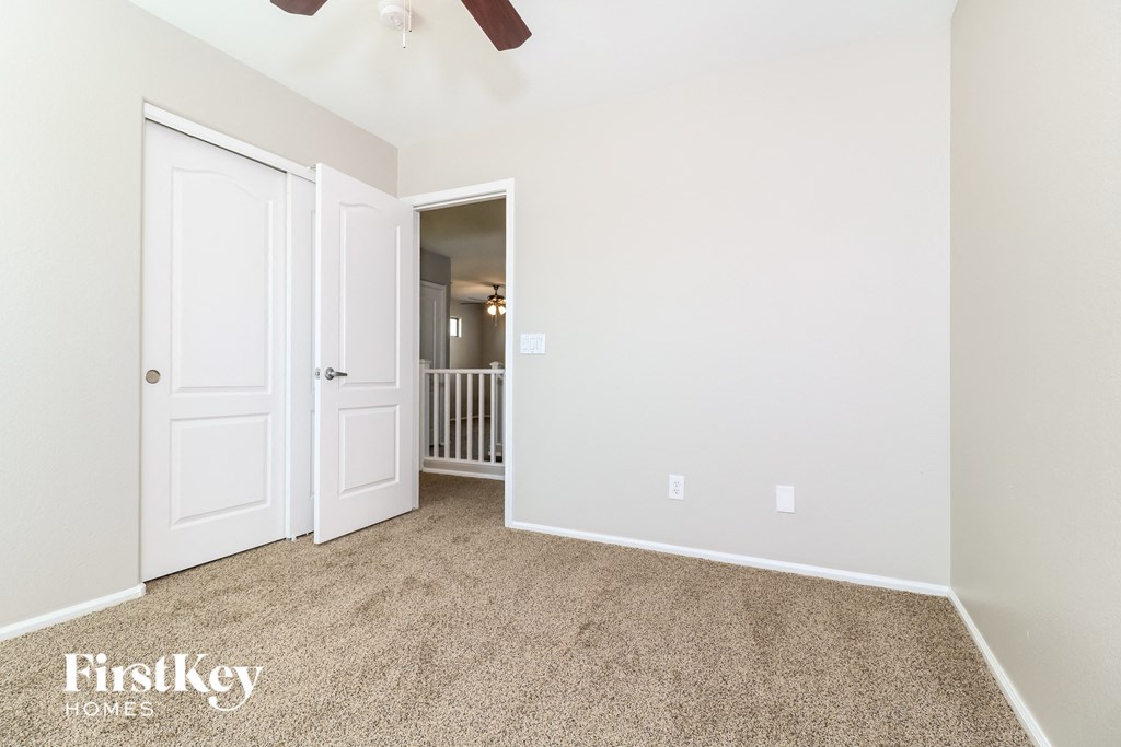 a living room with carpet and a door to a hallway