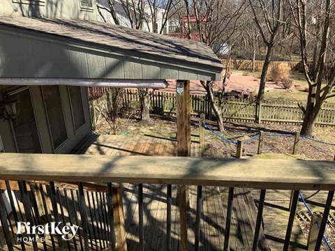 a backyard with a wooden deck and a house