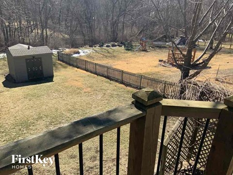 a backyard with a fence and a bird feeder