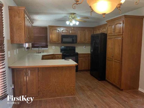 an empty kitchen with wooden cabinets and a white counter top