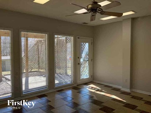an empty living room with a ceiling fan