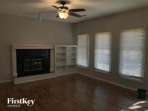 a living room with a fireplace and a ceiling fan