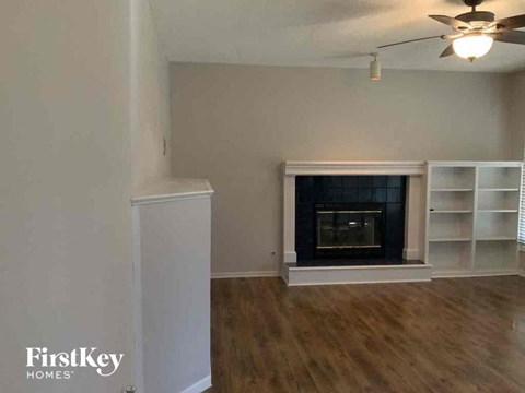 a living room with a fireplace and white shelves