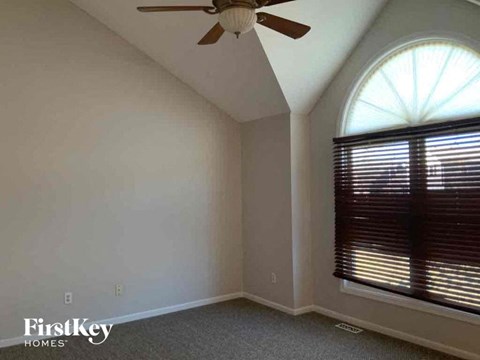 an empty room with a ceiling fan and a window