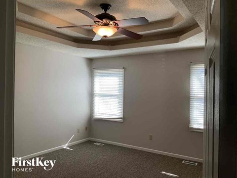 a bedroom with a ceiling fan and a window