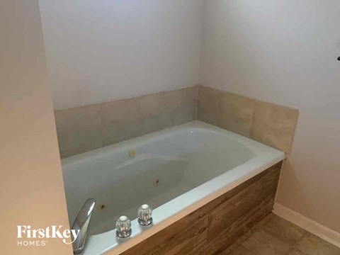 a large jacuzzi tub in a bathroom with tiled walls and floors