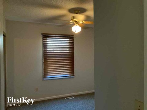 an empty room with a ceiling fan and a window