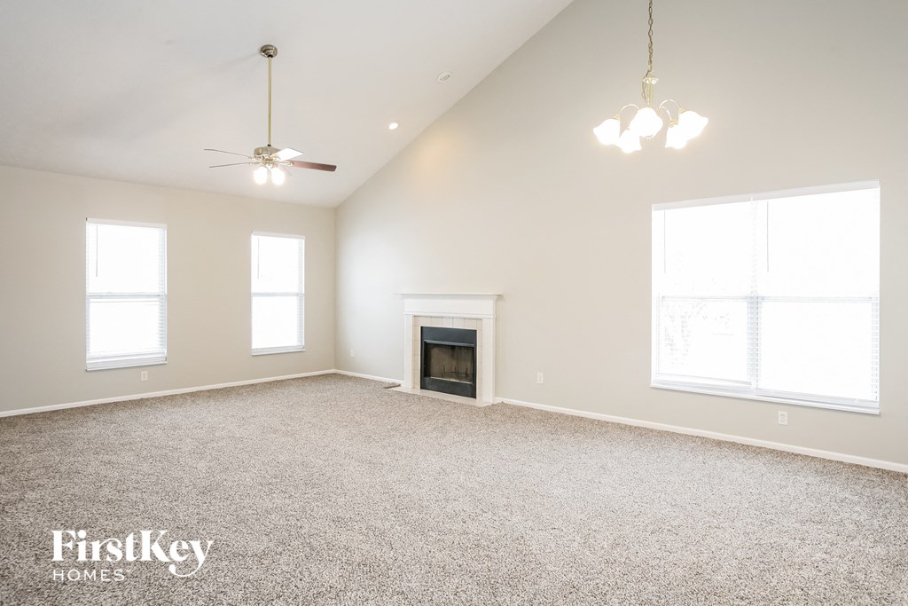 a spacious living room with a fireplace and a carpeted floor