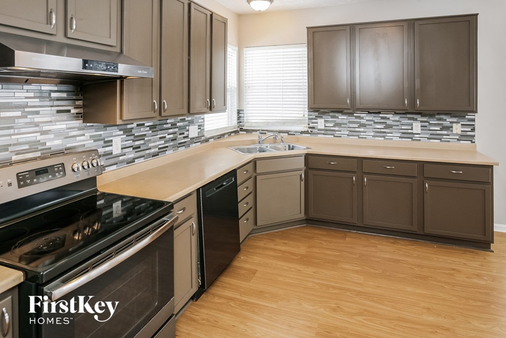 a remodeled kitchen with wood flooring and stainless steel appliances