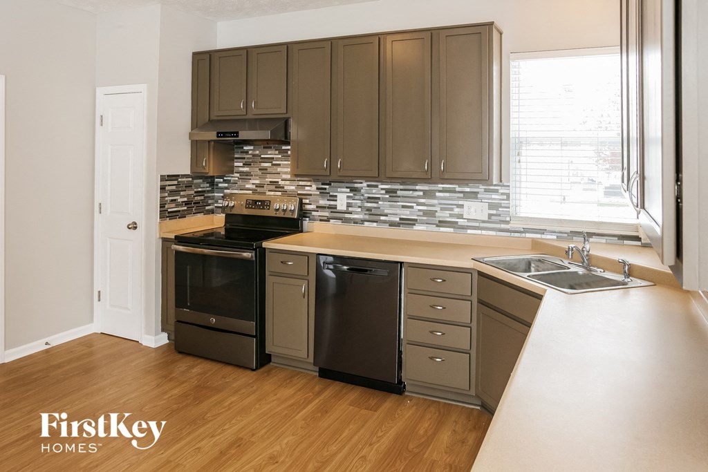 an updated kitchen with stainless steel appliances and wood flooring