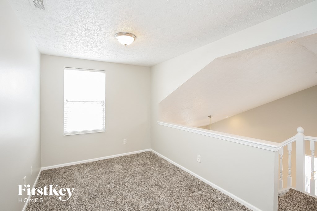 a bedroom with carpeted flooring and a window