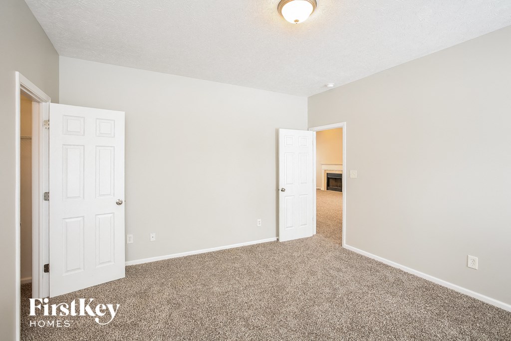 a bedroom with a carpeted floor and white doors
