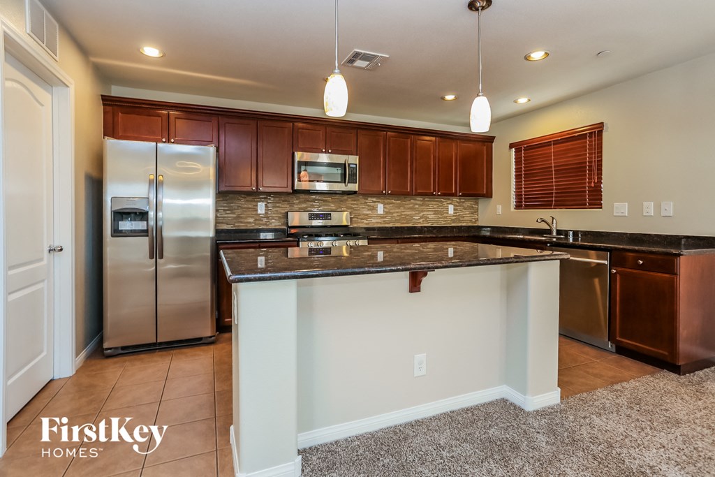 a kitchen with granite counter tops and stainless steel appliances