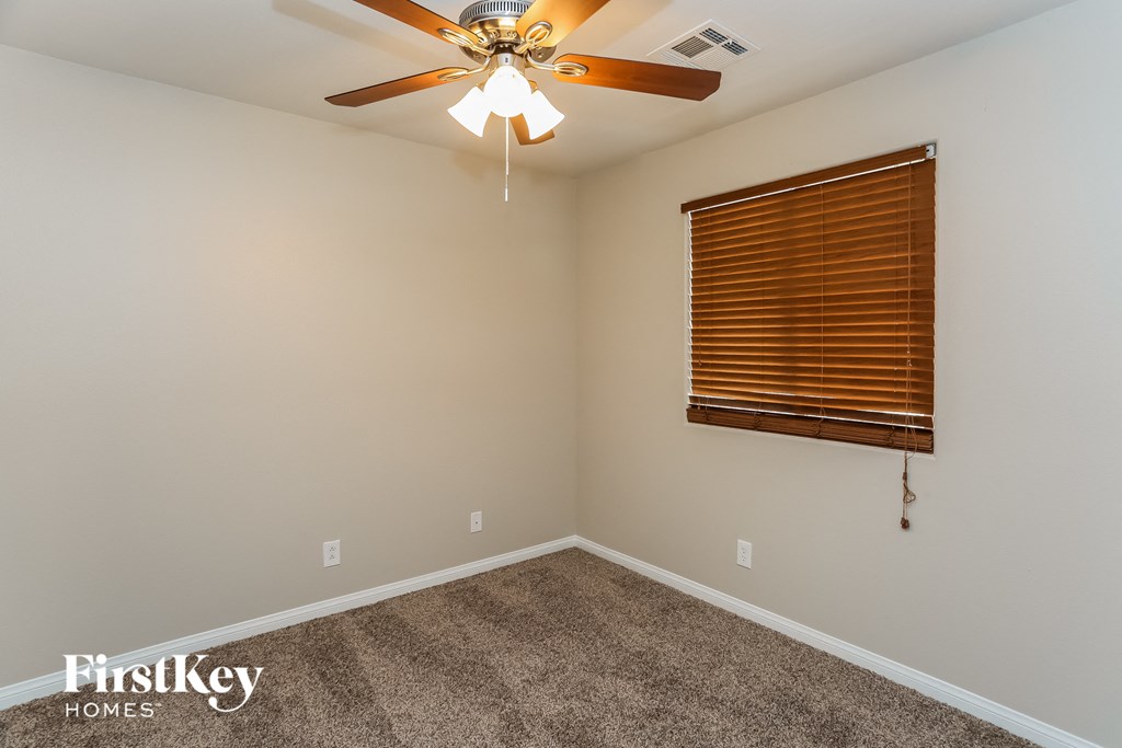 the living room has a ceiling fan and carpet