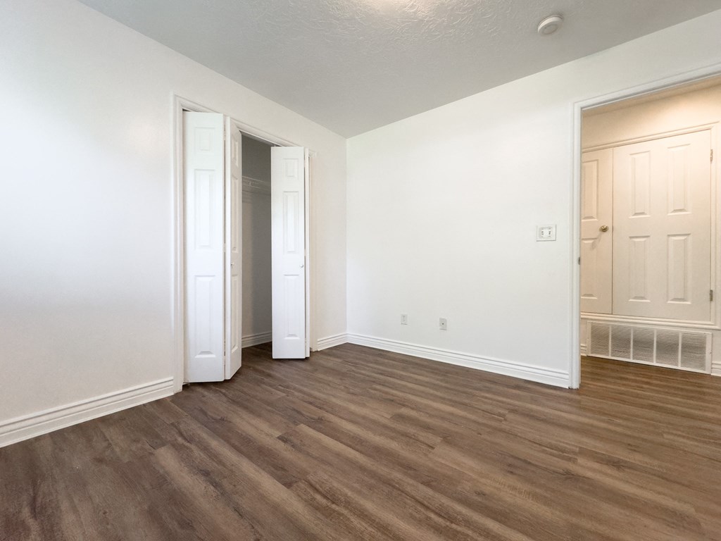 an empty living room with white walls and wood flooring