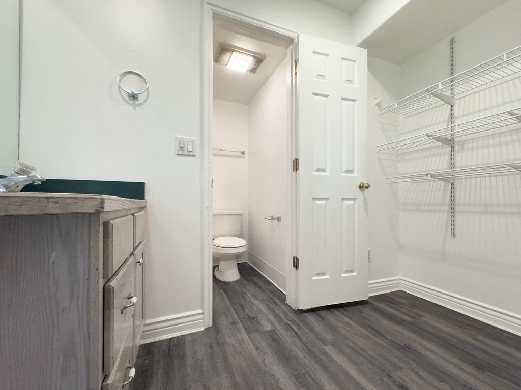 a bathroom with a white door and a toilet and a closet