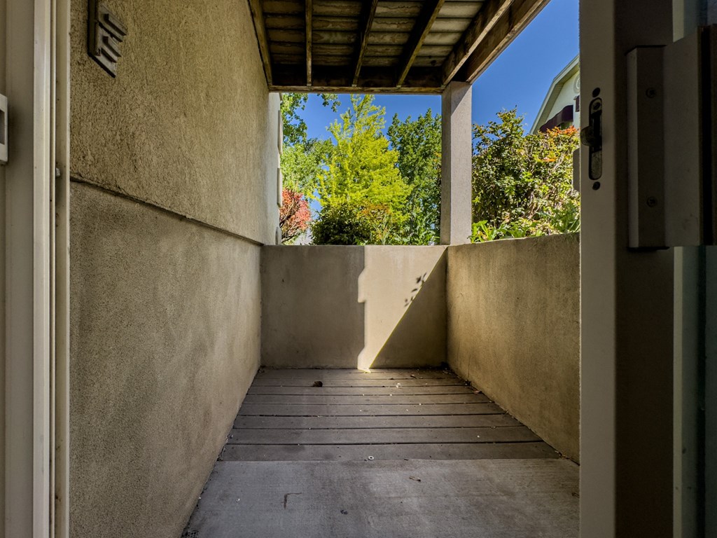 a long porch with a view of trees and a blue sky