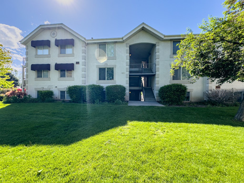 the front of a white house with a green lawn