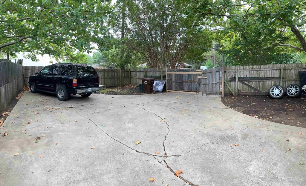 a car parked in a driveway next to a fence